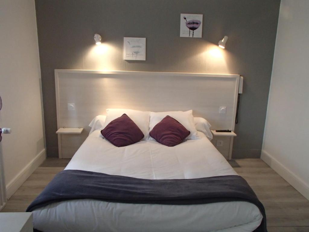 1 dormitorio con 1 cama grande y 2 almohadas en Logis Hôtel Le pont d'Arcole, en Riscle