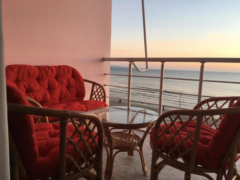 a living room with a table and chairs and the ocean at Bellavista apartment in Durrës
