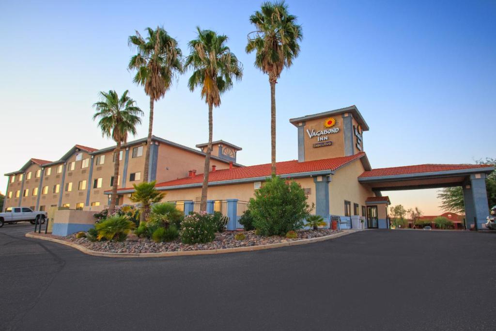 a hotel with palm trees in front of a building at Vagabond Inn Executive in Green Valley
