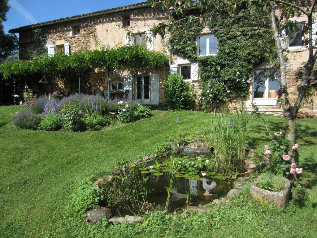 a garden in front of a house with a pond at La Basserie in Laguépie