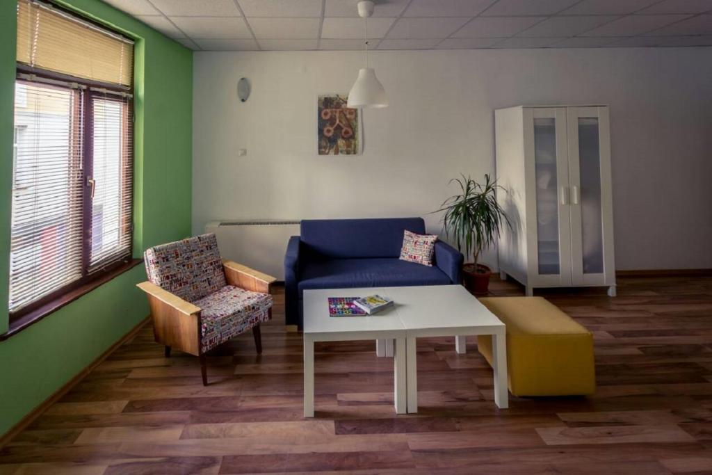 a living room with a blue couch and a table at 4 Rooms in Plovdiv