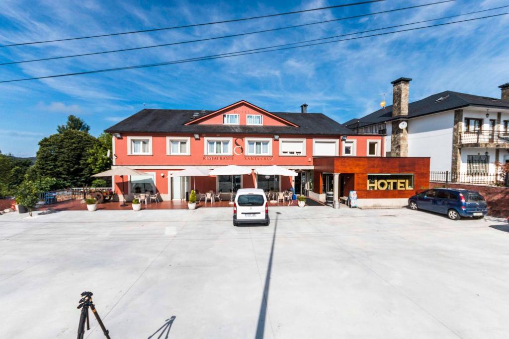 una furgoneta blanca estacionada en un estacionamiento frente a un edificio en Hotel Santa Cruz, en Montaos