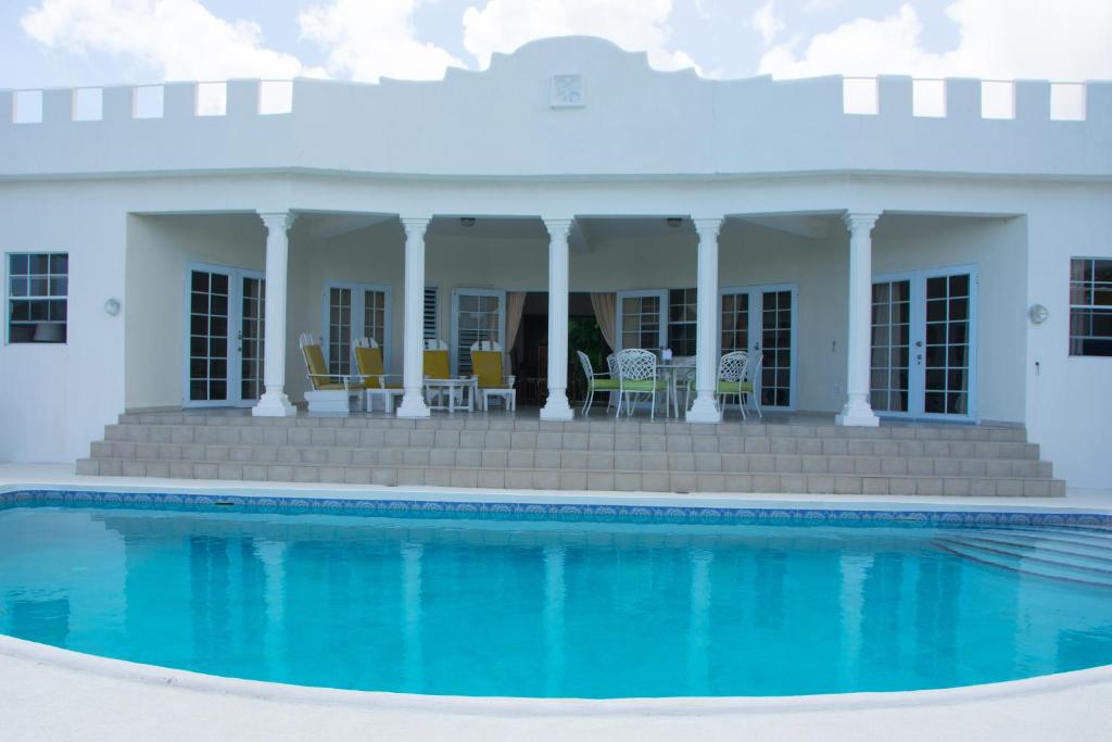 a house with a swimming pool in front of it at Castles In Paradise Villa Resort in Vieux Fort