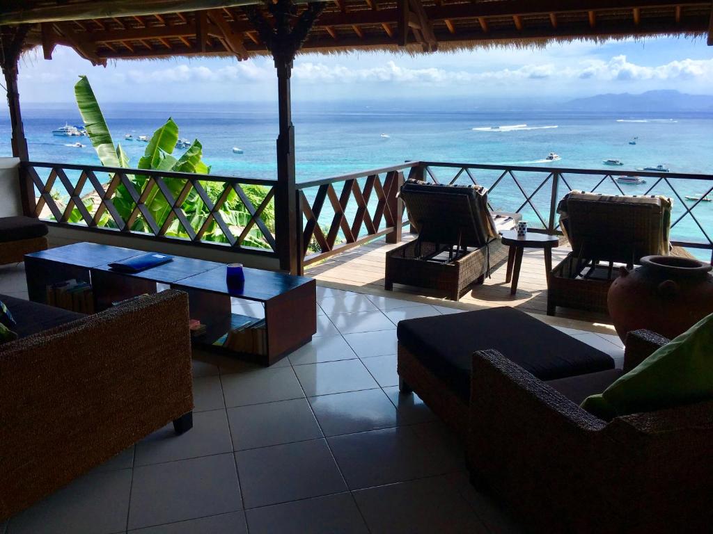 uma vista para o oceano a partir de um resort com cadeiras e mesas em Villa Atas Lembongan em Nusa Lembongan