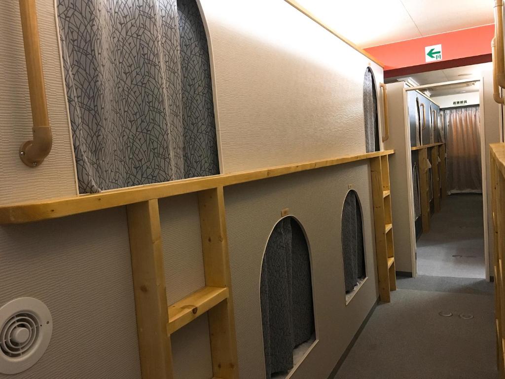 a hallway in a train with wooden shelves at Hostel Mallika in Hiroshima