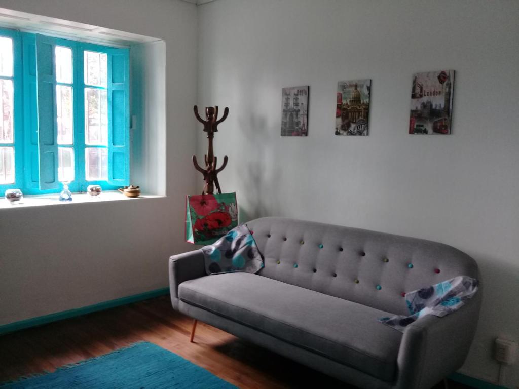 un soggiorno con divano e finestra di Hostal Casa Azul a Talca