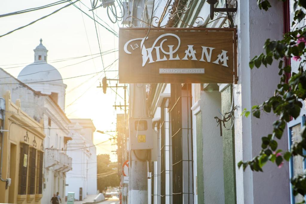 una señal para un restaurante al lado de un edificio en Aroha Villana Hostel, en Santa Marta