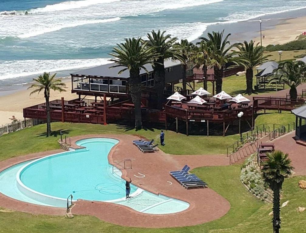 a resort with a swimming pool next to the beach at Beach Club Unit 207 in Mossel Bay