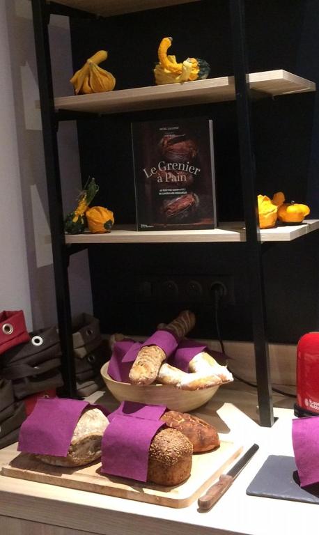 a shelf with a plate of bread and a book at Hotel-Restaurant Lann Roz / Côte Cuisine in Carnac