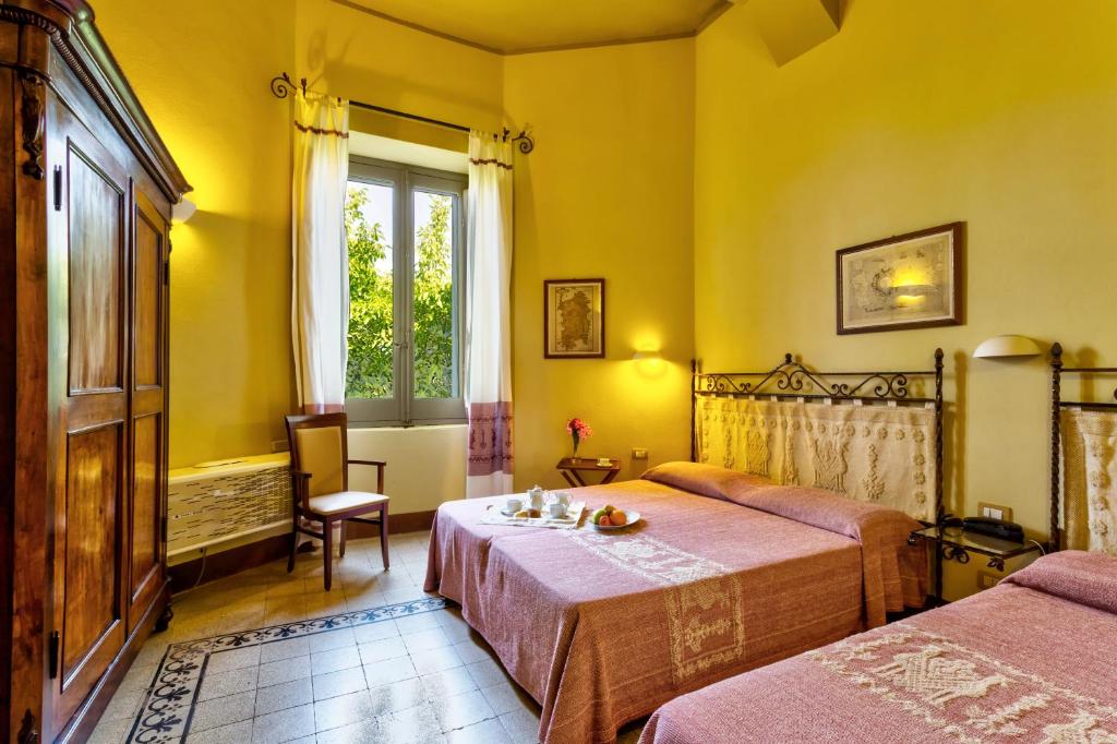 ein Hotelzimmer mit 2 Betten und einem Fenster in der Unterkunft Hotel Villa Gli Asfodeli in Tresnuraghes