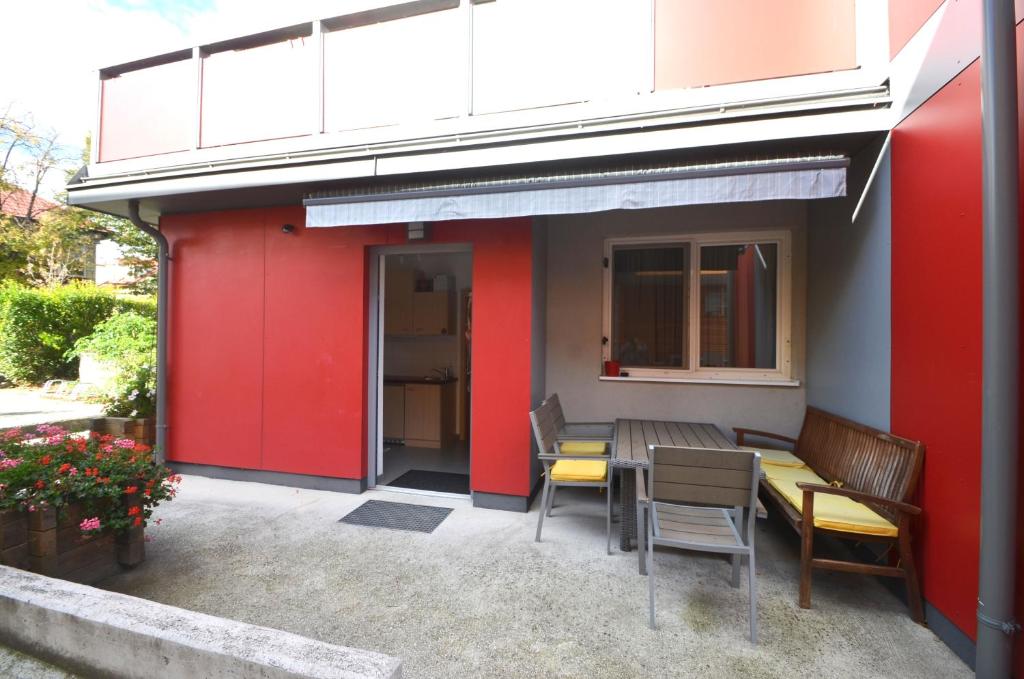 a red building with a table and chairs outside at Ferienwohnungen Gruber in Rust
