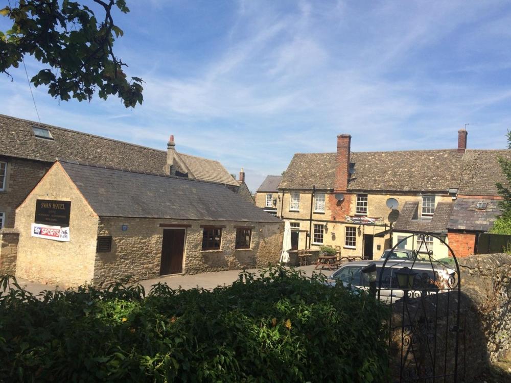 a group of buildings with a car parked in front at The Swan Hotel in Eynsham