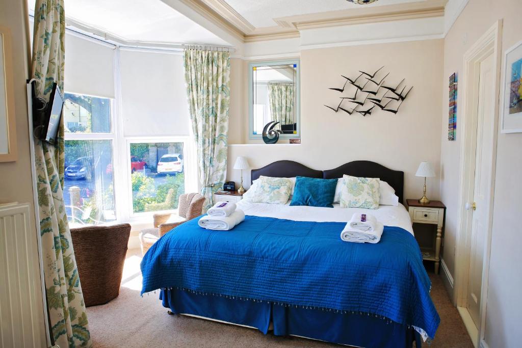 Un dormitorio con una cama azul y una ventana. en Blue Sky Bed and Breakfast, en St Ives