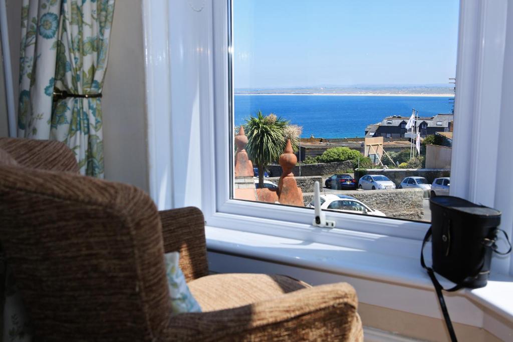 a room with a window with a view of the ocean at Blue Sky Bed and Breakfast in St Ives