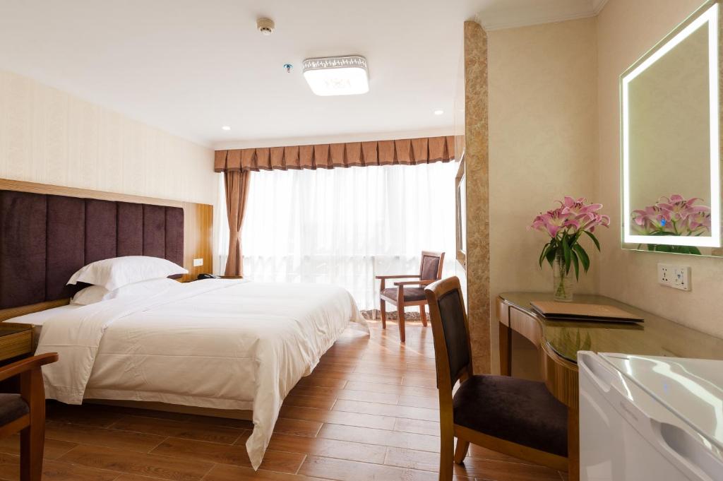 Guangzhou Compass Hotel tesisinde bir odada yatak veya yataklar