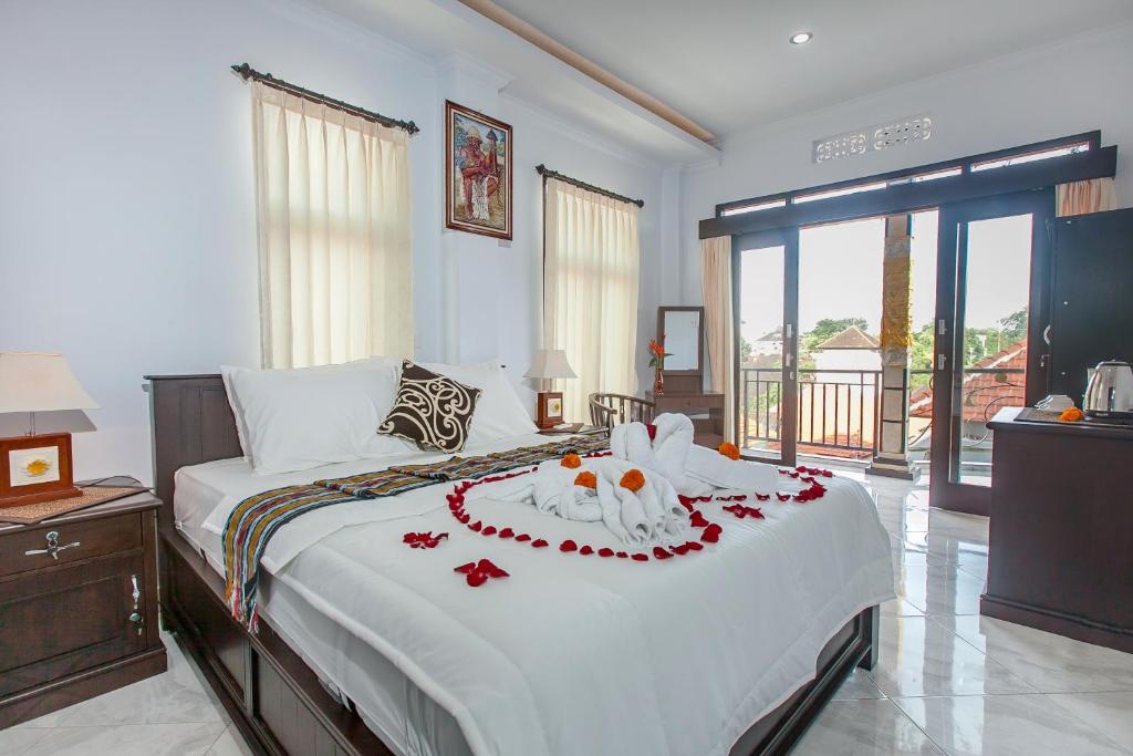 een slaapkamer met een groot bed met bloemen erop bij Yoga's House in Ubud