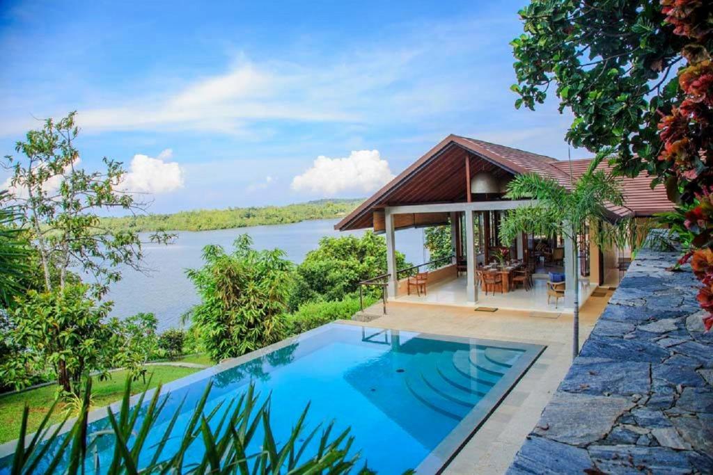 a villa with a swimming pool and a house at Sea Heart House on Koggala Lake in Koggala