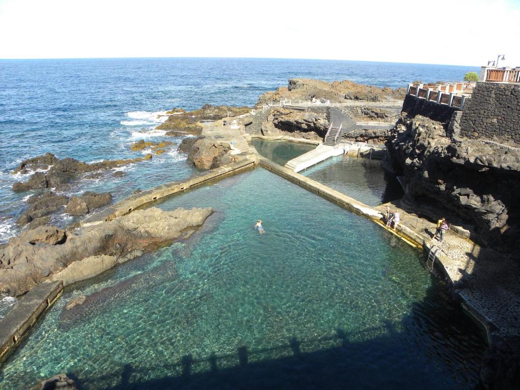 una piscina en el océano con gente en ella en Apartamento en piscinas naturales., en Barlovento