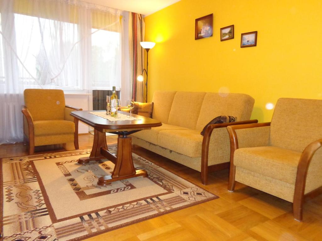 sala de estar con sofá, 2 sillas y mesa en Apartament na Nowickiego en Nałęczów