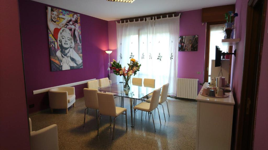 une salle à manger avec des murs violets, une table et des chaises dans l'établissement L'Isola di Romy, à Milan