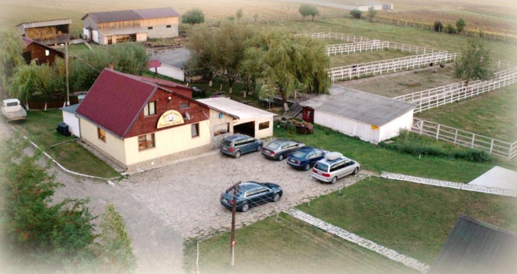 una vista aérea de una casa con coches aparcados fuera en Pensiunea ,,La struti", en Tîrgu Neamţ