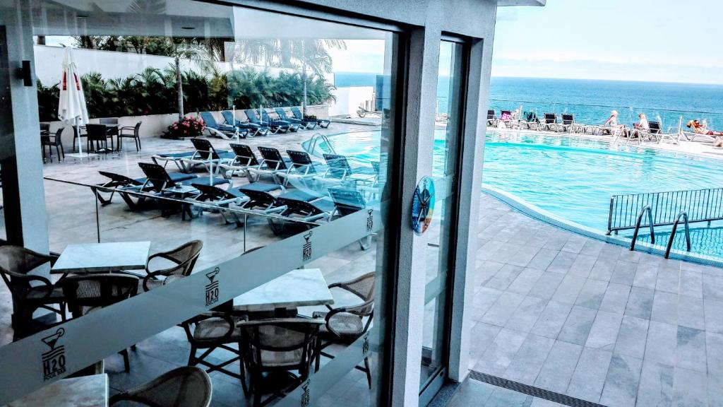 uitzicht op een zwembad vanuit een hotelkamer bij Fantastic SEA VIEW Studio in Funchal in Funchal