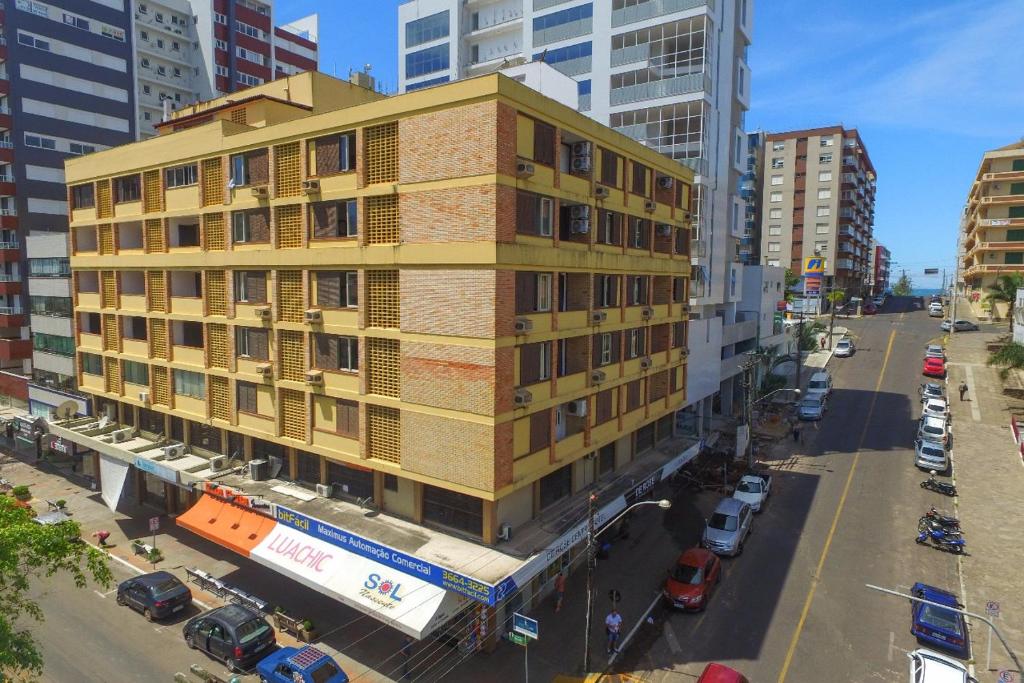 a yellow building on a city street with buildings at De Rose Centro Hotel in Torres