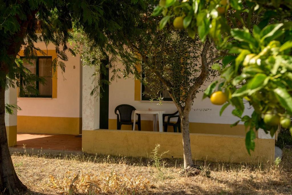 ein Haus mit Tisch und Stühlen und Bäumen in der Unterkunft Markádia in Odivelas