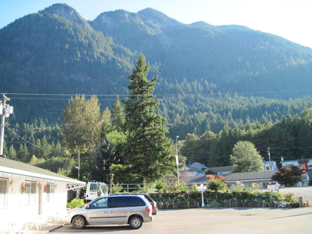 a car parked in a parking lot in front of a mountain at Alpine Motel in Hope