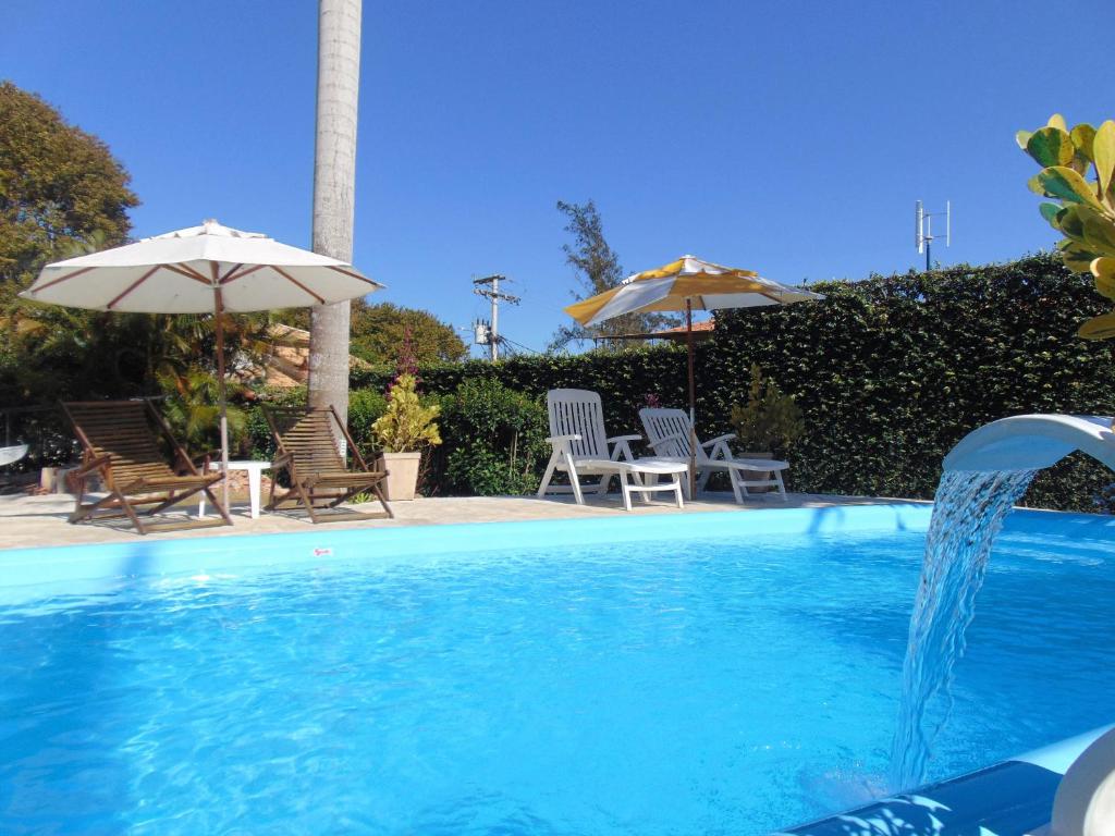 een zwembad met een fontein bij Apartamentos Portal da Ferradura in Búzios