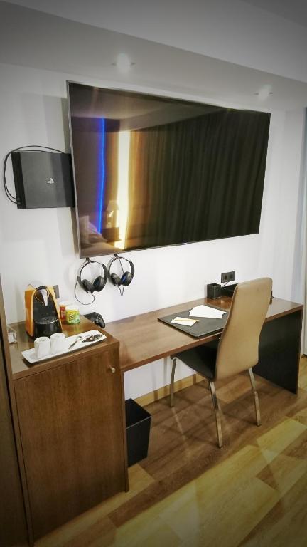 a desk and a chair in a room with a television at MB Boutique Hotel - Adults Recommended in Nerja