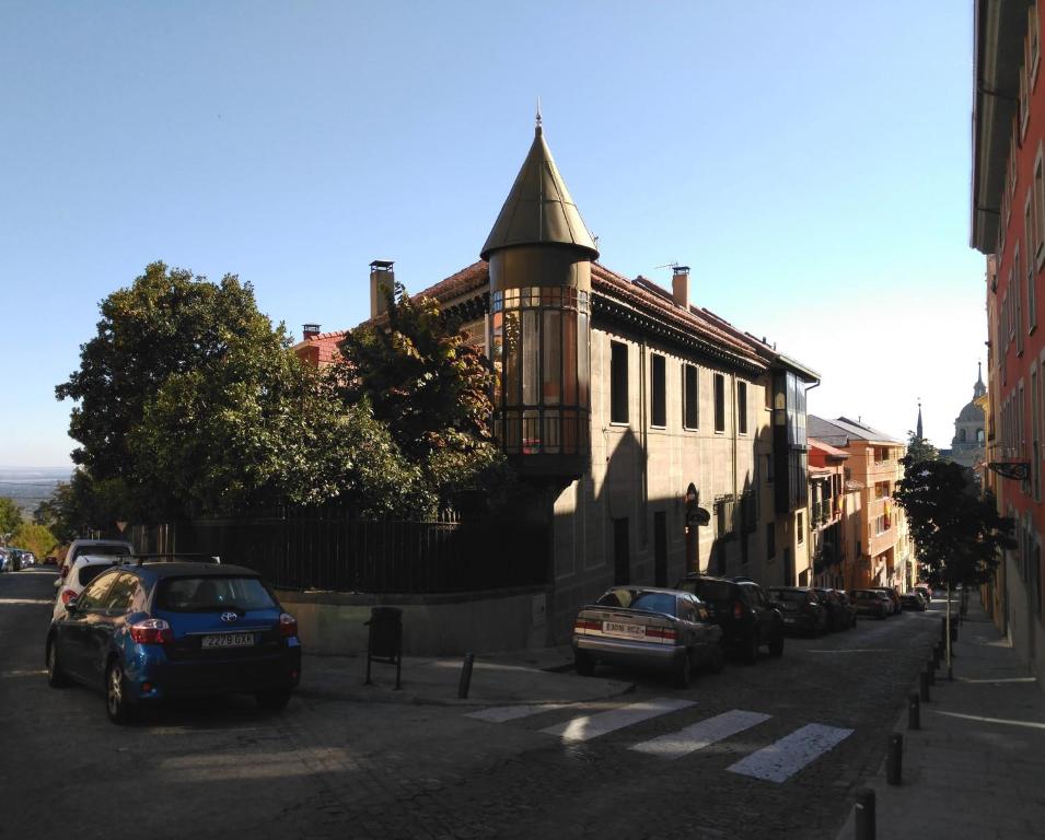 a street with cars parked in front of a building at Posada Don Jaime in San Lorenzo de El Escorial