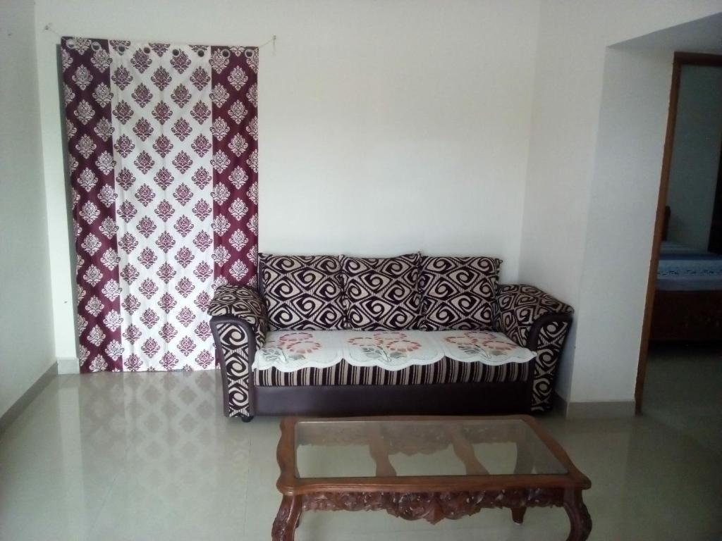 sala de estar con sofá y 2 cortinas en G k Homestay en Tirupati