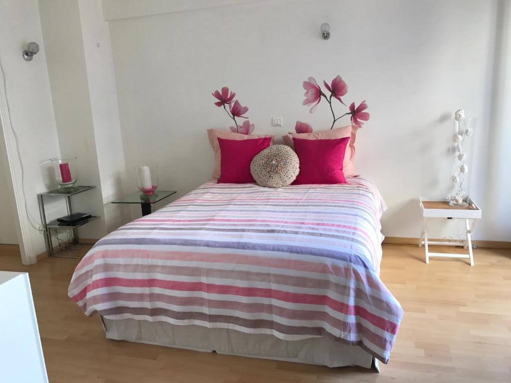 ボーソレイユにあるAppartements 5MIN MONTE CARLOのベッドルーム1室(ピンクと紫の枕が付いたベッド1台付)