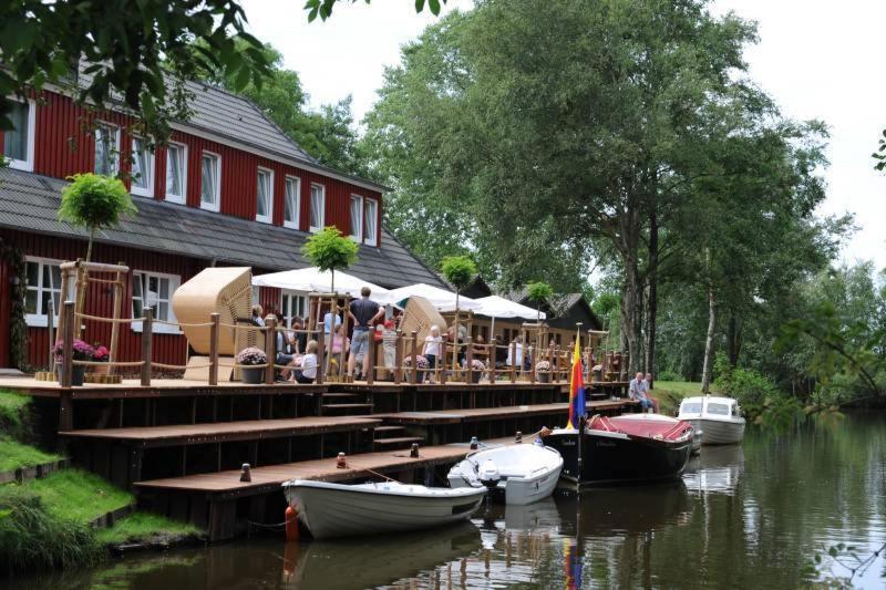 a restaurant on a dock with boats on the water at Bootshaus in Bedekaspel