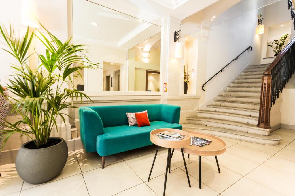 a living room with a green couch and a table at Apparthotel Privilodges Le Royal in Annecy