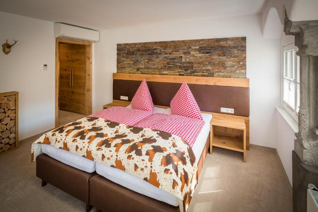 - une chambre avec un lit doté d'oreillers roses et bruns dans l'établissement Hotel Alte Schule, à Lindau