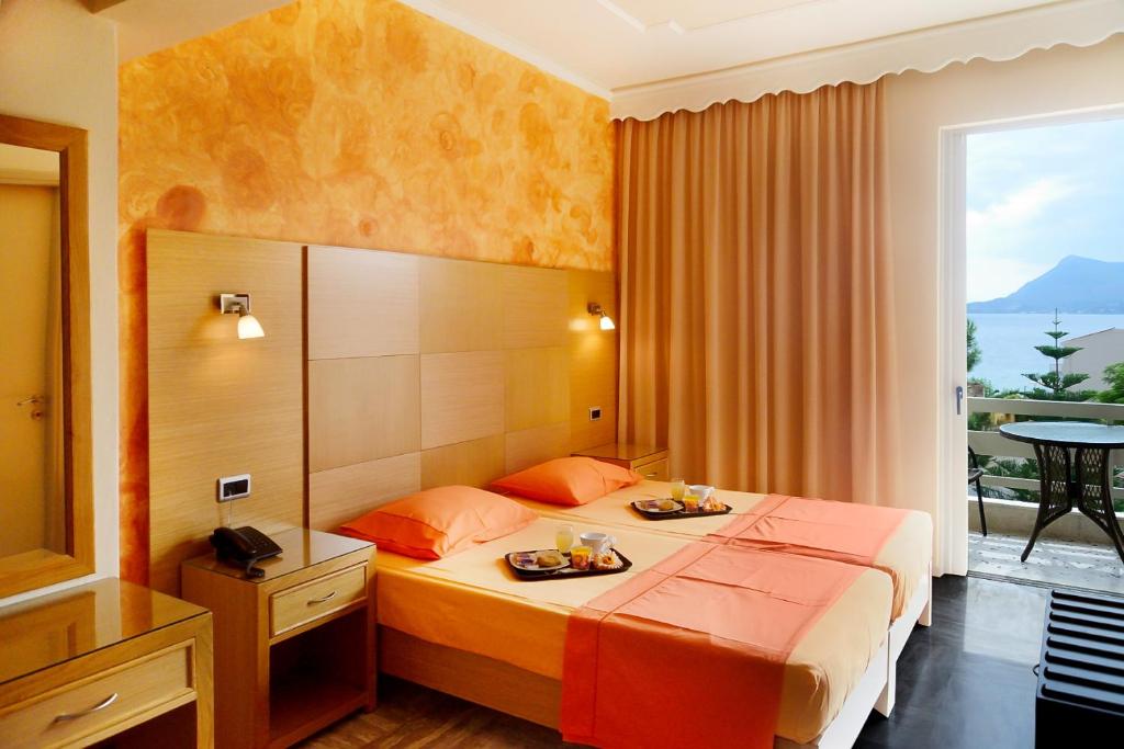 a hotel room with a bed with two plates of food on it at Studios Asteria in Loutra Edipsou
