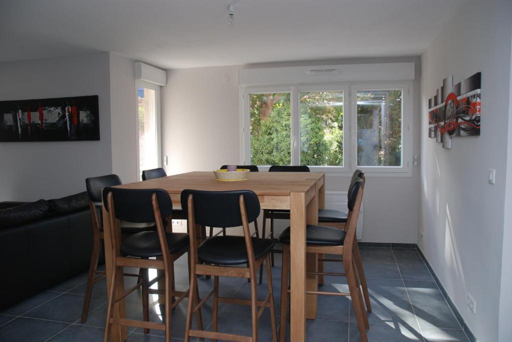 une salle à manger avec une table et des chaises en bois dans l'établissement Le Prado de Sète, à Sète