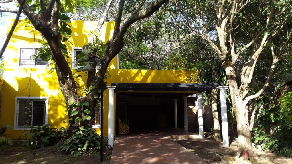 een geel gebouw met een garage met bomen voor de deur bij Casa Paso de la Patria in Corrientes