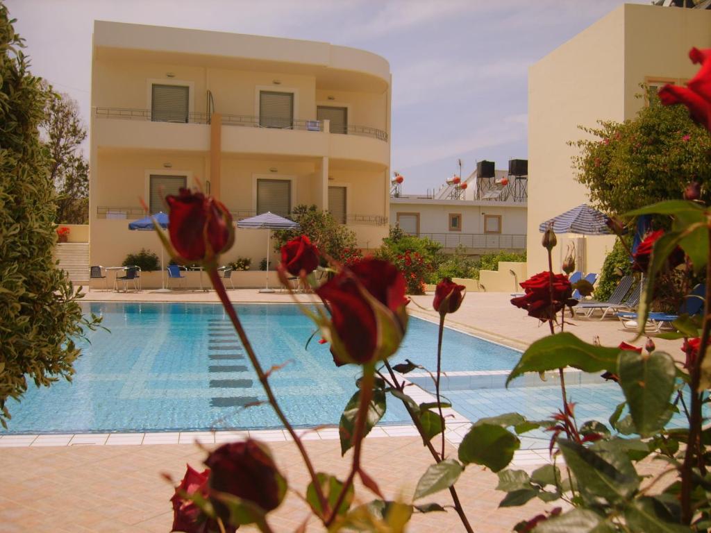 un hotel con piscina frente a un edificio en Atlantica Yakinthos, en Kato Daratso