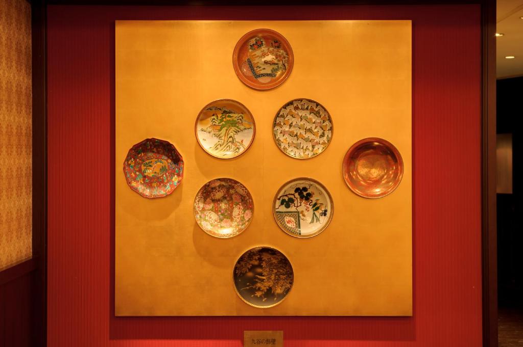 a bunch of plates hanging on a wall at Kanazawa Hakuchoro Hotel Sanraku -Natural Hot Spring- in Kanazawa