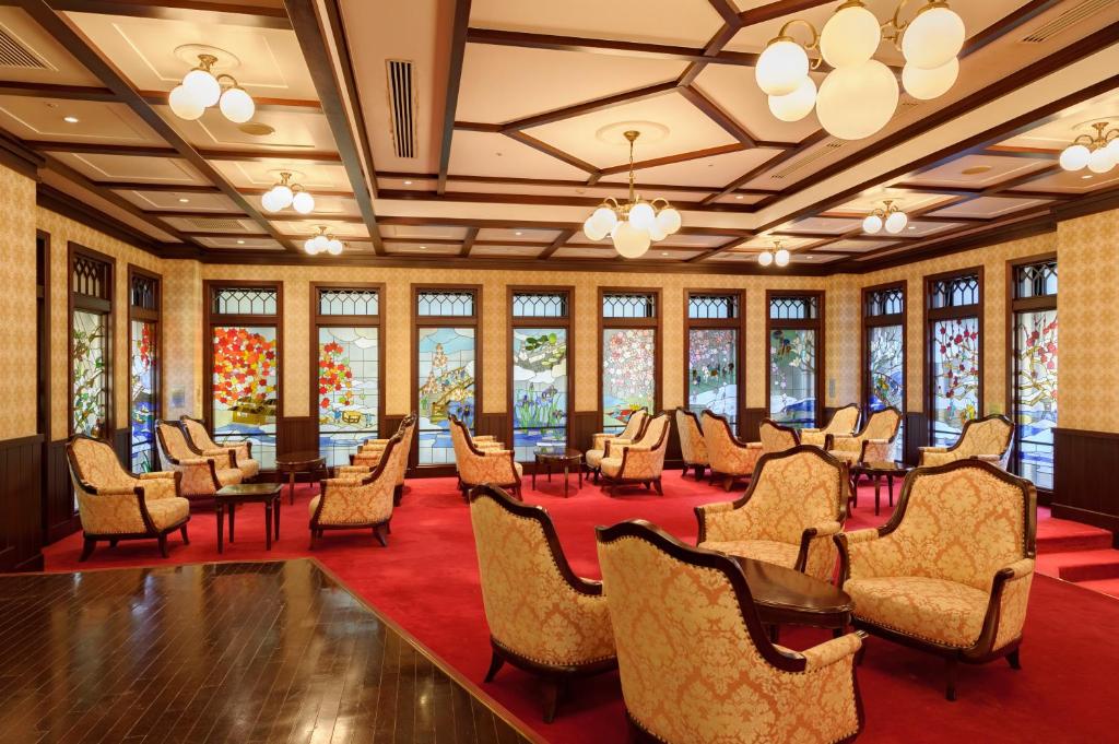a large room with chairs and tables and windows at Kanazawa Hakuchoro Hotel Sanraku -Natural Hot Spring- in Kanazawa