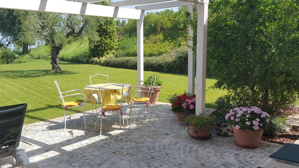 a patio with a table and chairs in a yard at L'Orso e L'Ape B&B in Giulianova