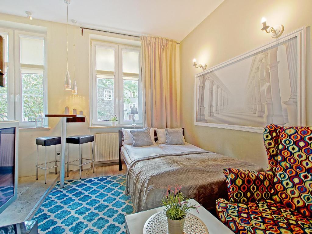 een woonkamer met een bed en een bank bij Apartament Kameralny V in Gdańsk