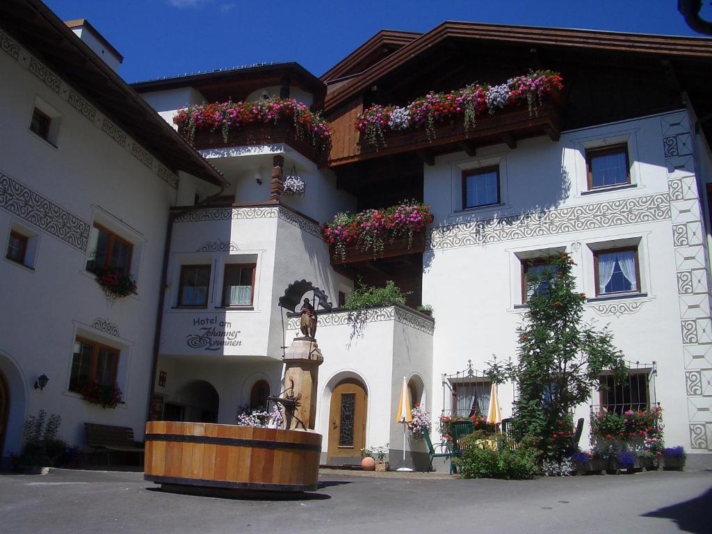 a large white building with flower boxes on it at Aparthotel Garni am Johannesbrunnen in Fiss