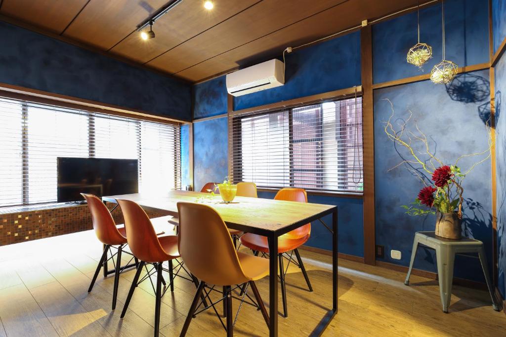 uma sala de jantar com paredes azuis e uma mesa e cadeiras em Copain Kurumi em Kanazawa