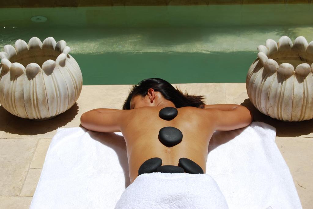 a man laying on a towel in a swimming pool at Riad Flam & Spa in Marrakech