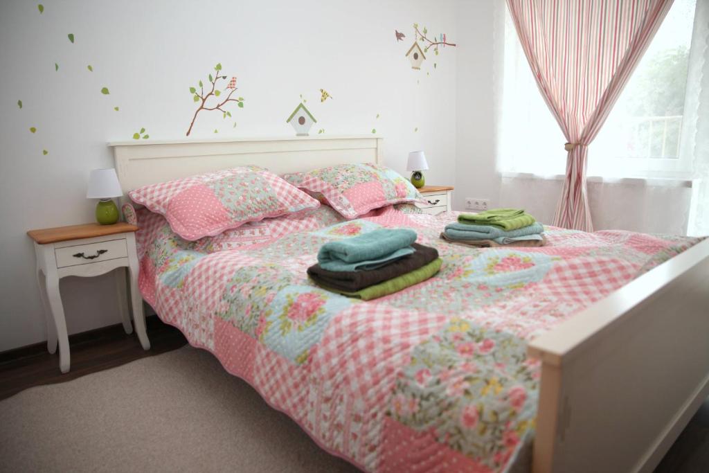 a bedroom with a bed with blankets and pillows at Rozmaring Pihenőház in Velence