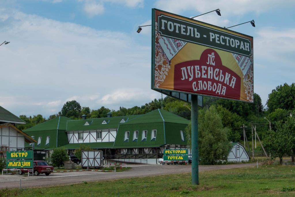 um sinal para um restaurante em frente a um edifício em Hotel Lubenska Sloboda em Vilʼshanka